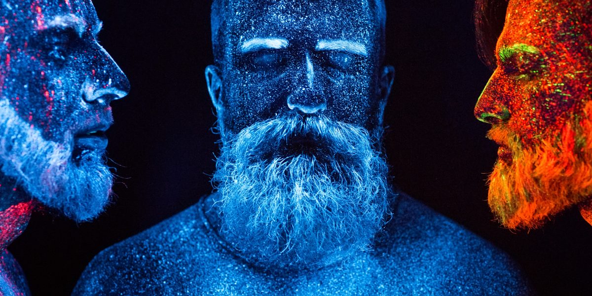 Porträt dreier bärtiger Männer mit fluoreszierenden Pulvern