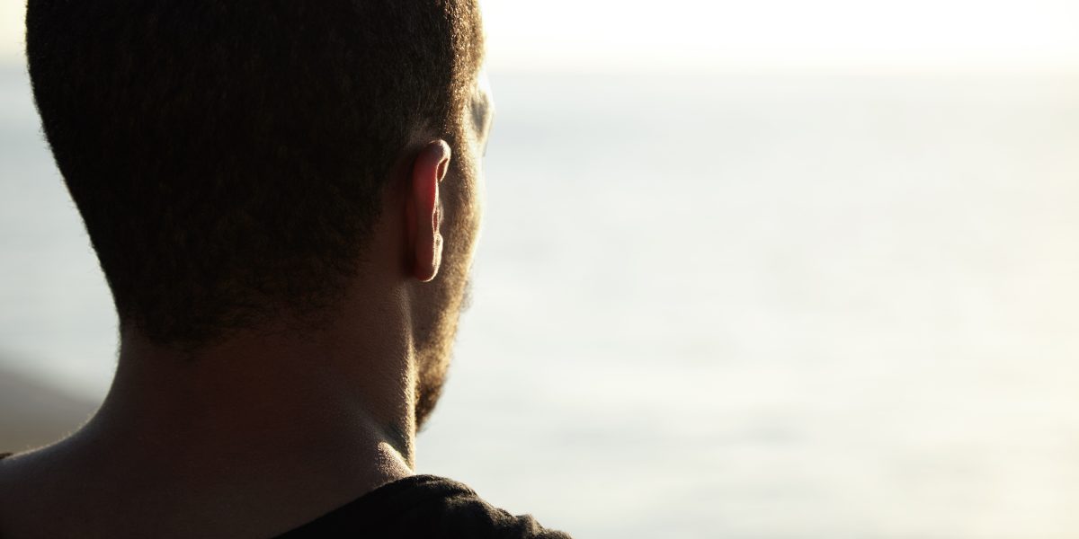 back shot handsome dark skinned young athlete enjoying sunny summer days ocean contemplating sunrise